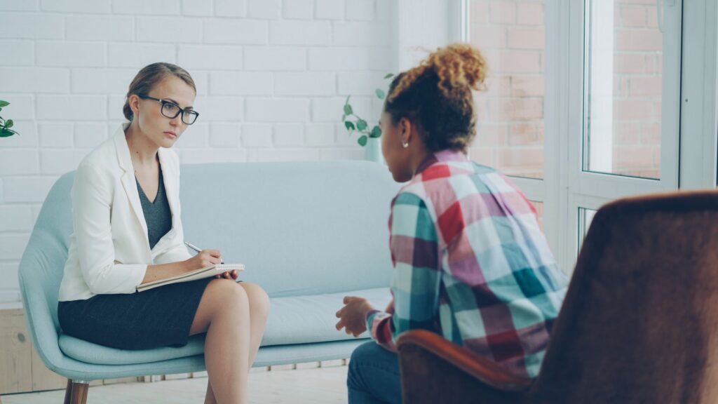 Two professionals in a relaxed conversation in a bright office
