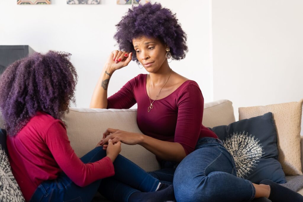 A parent and child talking together on a couch
